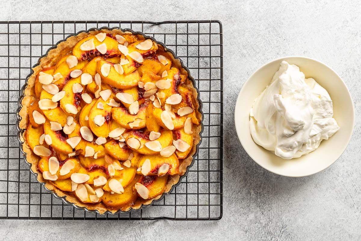 Taste of Home Peach Tart recipe photo of the baked tart with whipped cream.