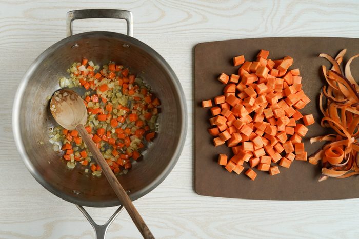 Adding cubed sweet potato to sautéed vegetable soup base