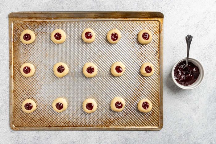 Taste of Home Raspberry Thumbprint cookies photo of the portioned dough into 1 inch balls, pressed with thumb and filled with seedless raspberry jam.