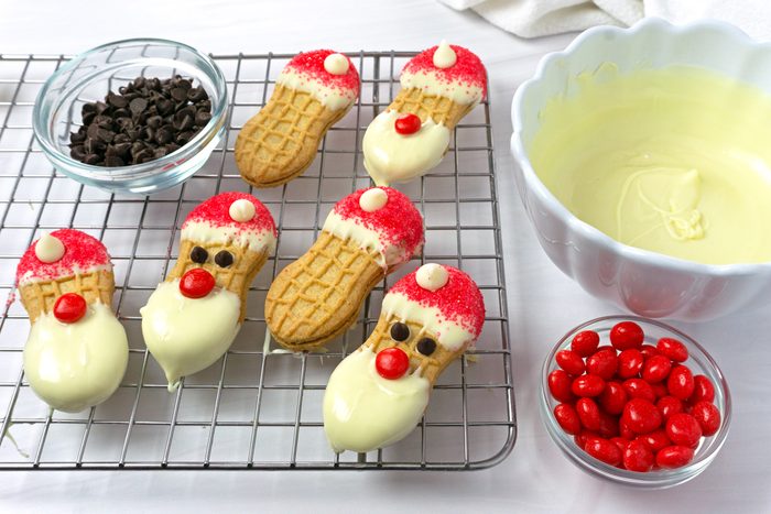 Adding sprinkles, red hot noses and eyes to Santa Claus cookies for Taste of Home RMS 21624