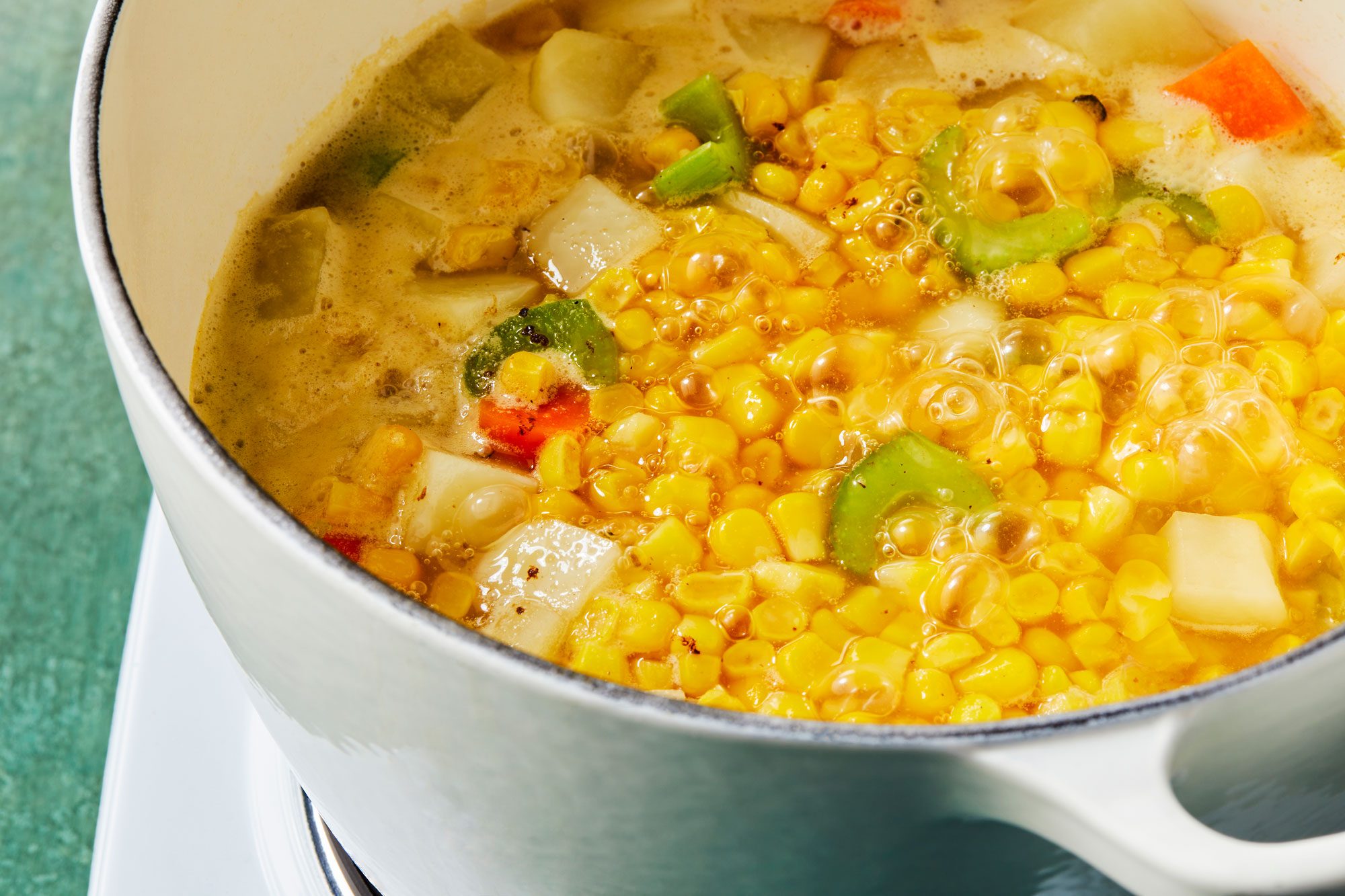 Close shot of reduce heat; cover and simmer until vegetables are tender; induction; green texture surface;