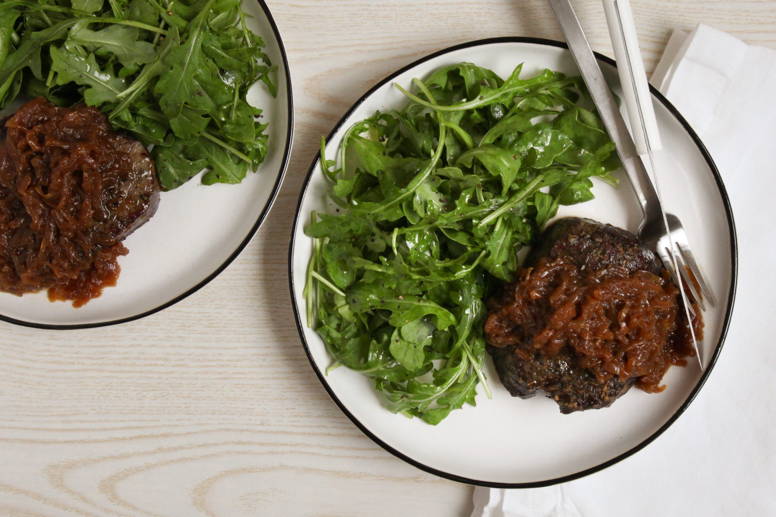 Filet mignon topped with caramelized onions and served with an arugula salad