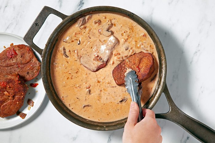 Return meat to skillet and turn to coat with sauce; overhead shot;