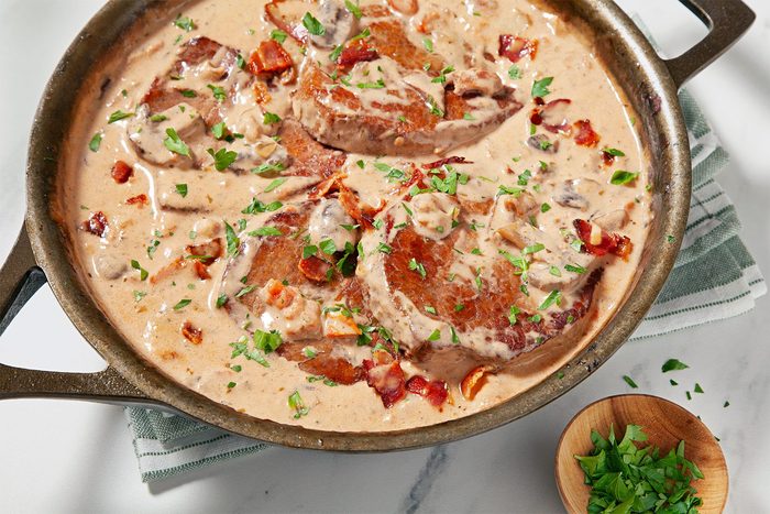wide shot of oven swiss meat garnished with fresh parsley