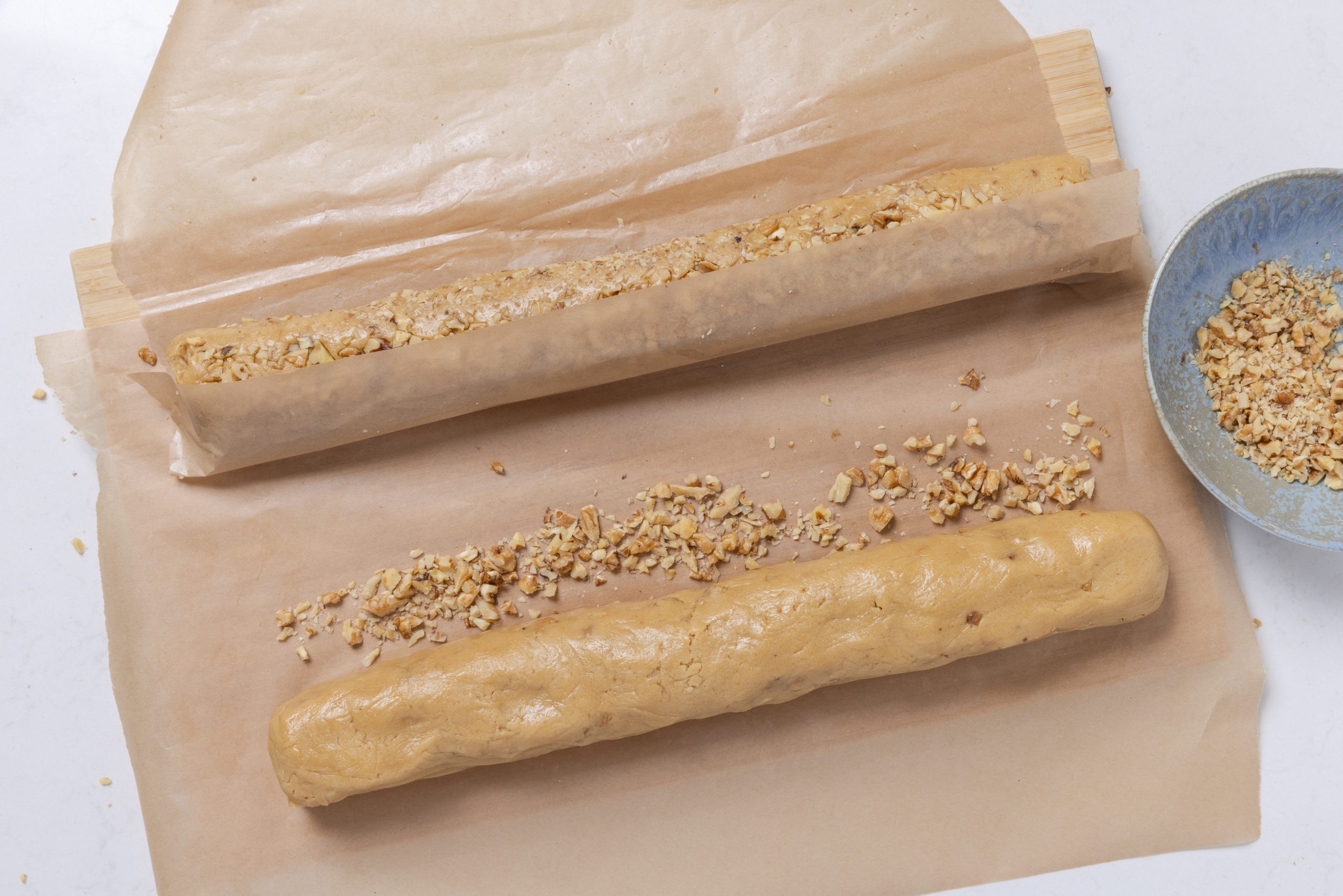 Cookie dough being rolled to go in the fridge.