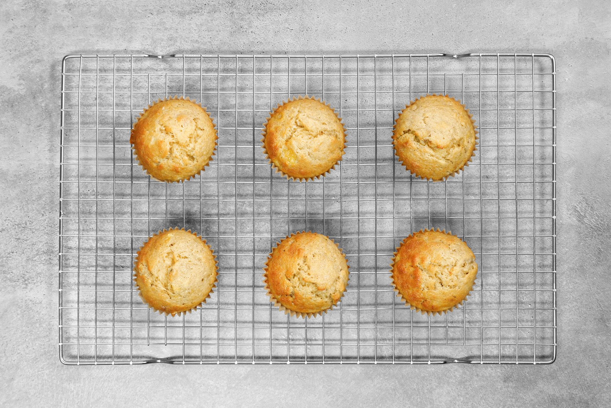 overhead shot; grey background; Banana Nut Muffins placed over wired rack;