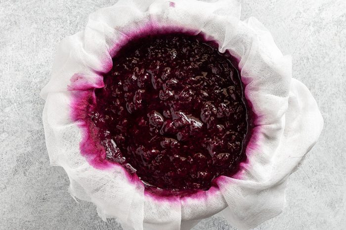 Taste of Home Blueberry Jelly Recipe photo of straining the blueberries through a cheese cloth.