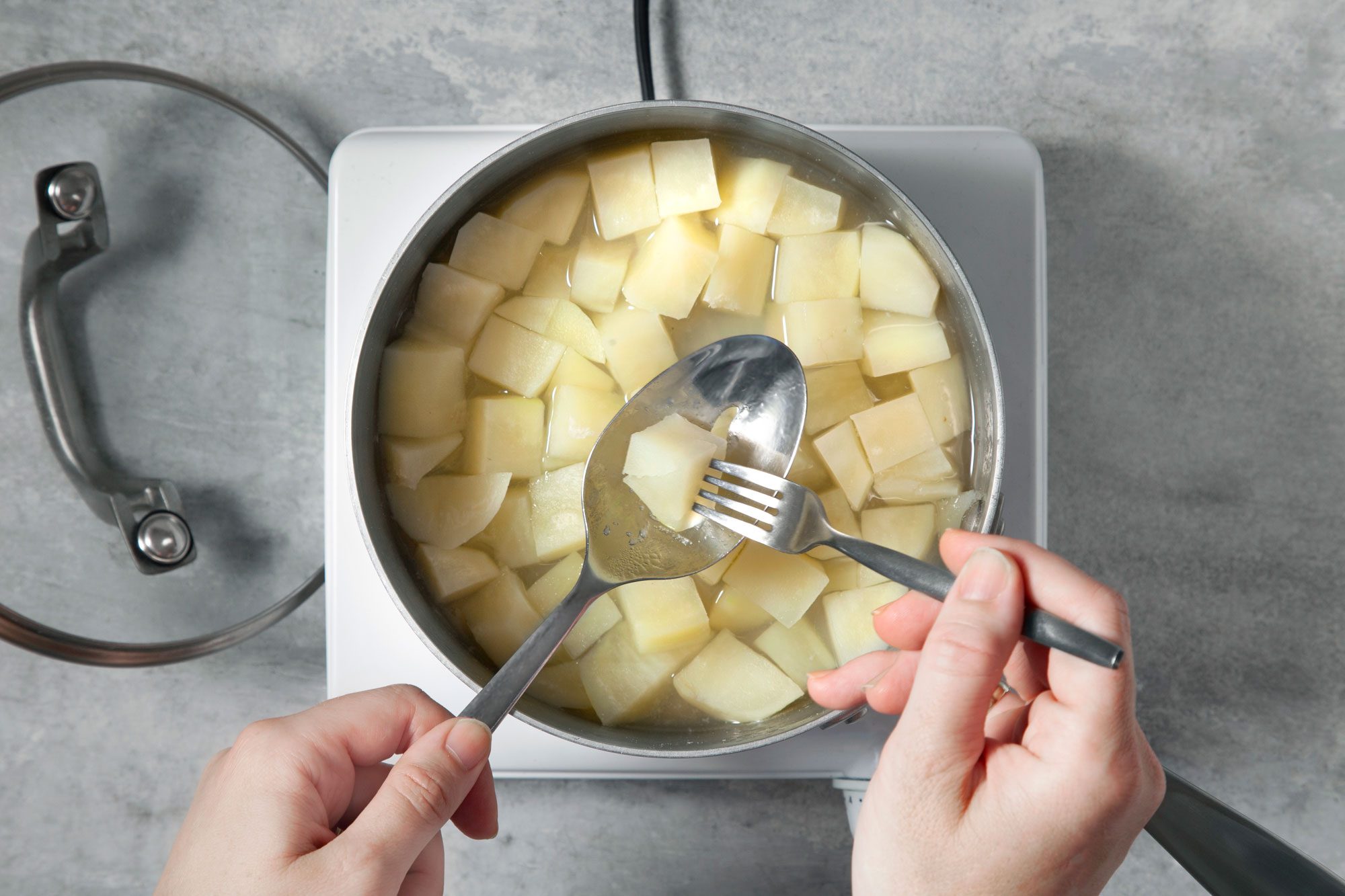 Saucepan filled with cubed potatoes simmering in water