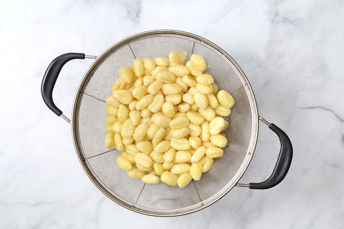 Cooked Gnocchi Noodles In Strainer for Gnocchi Alfredo recipe for Taste of Home