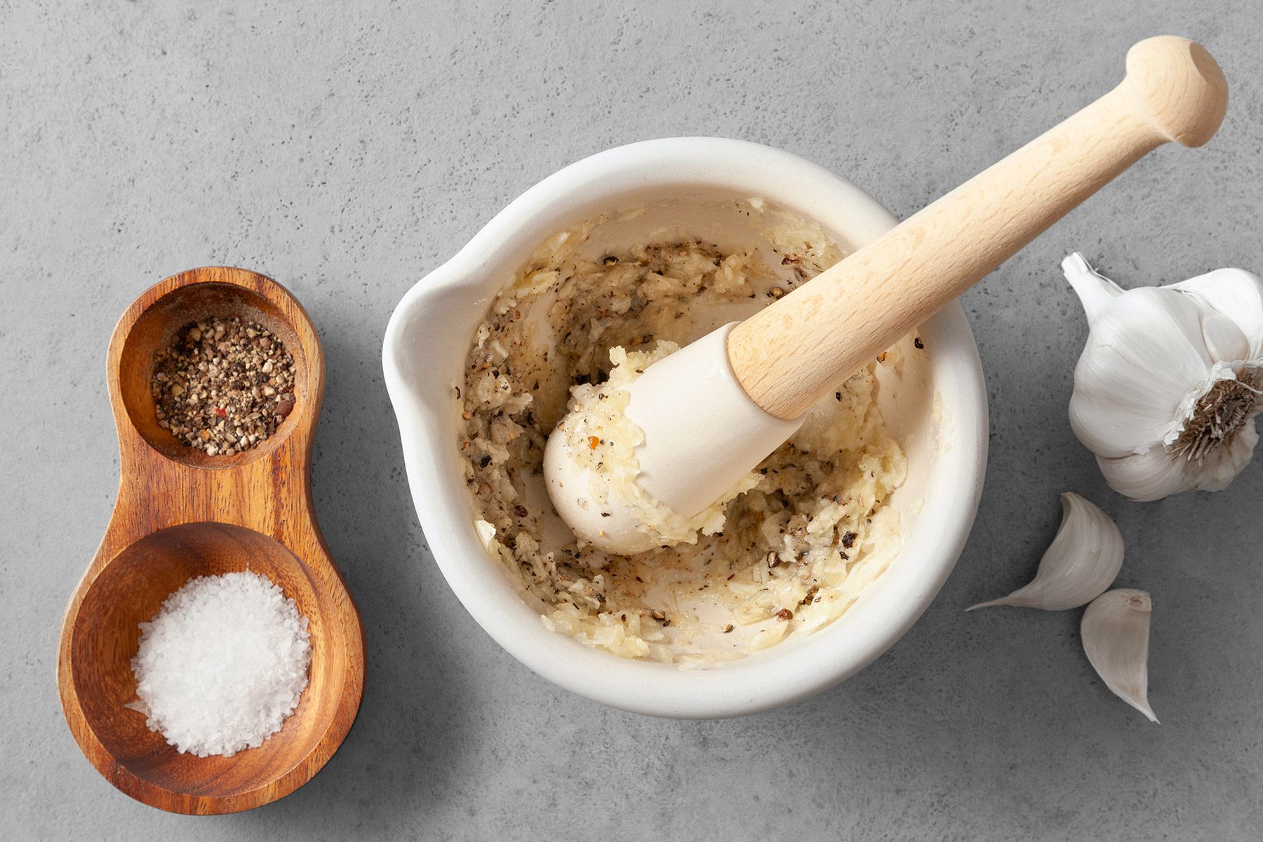 With a mortar and pestle, crush garlic cloves with salt and pepper.