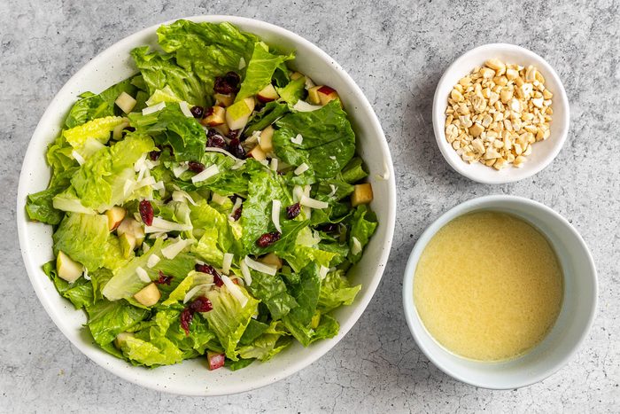 Taste of Home Holiday Salad recipe photo of the salad with the dressing and chopped cashews.