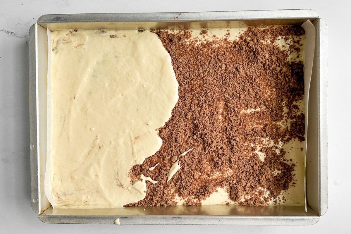 Unbaked Taste of Home Honey Bun Cake in a metal baking pan on a marble surface