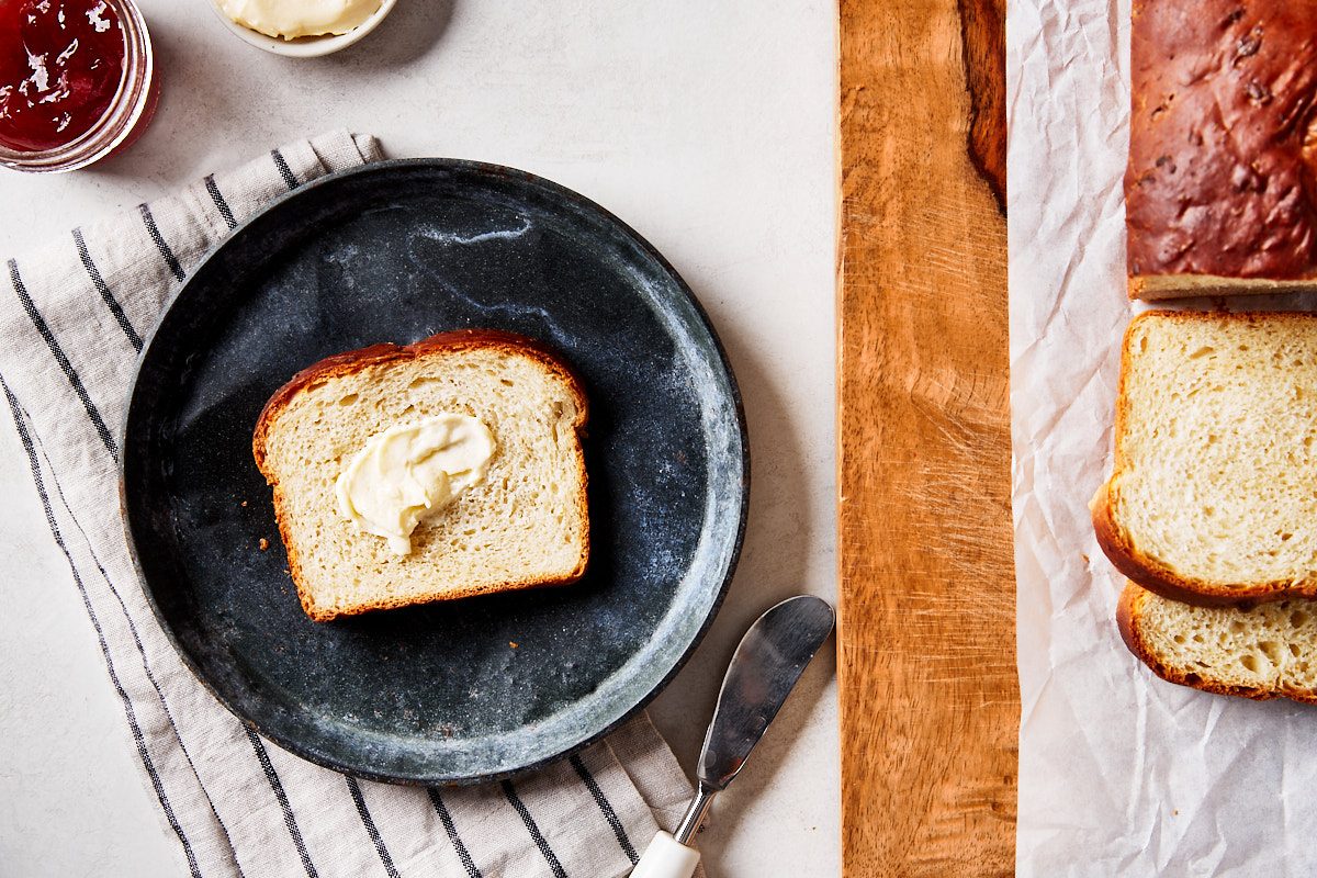Honey Oat Bread Hero- close up slice of bread with butter spread on