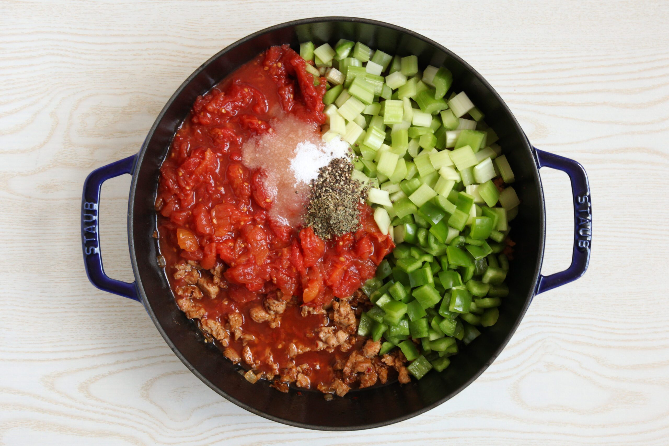 Adding vegetables and seasoning to soup