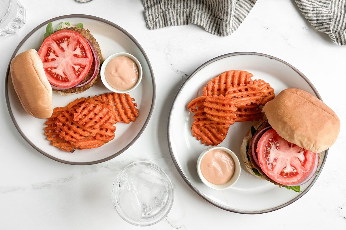 Taste of Home Lentil Burger on ceramic plates with waffle fries