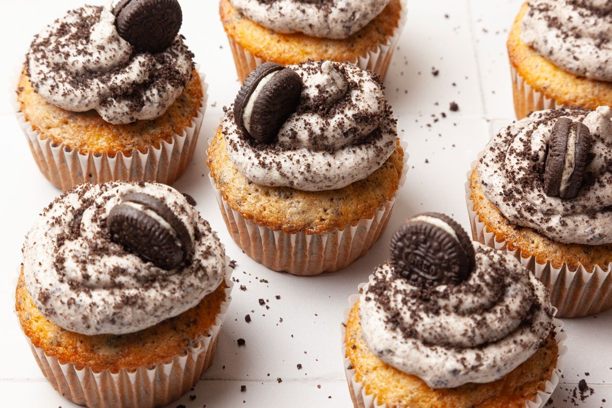 Taste of Home Oreo Cupcakes, on a white tile, oreo crumbs on surface