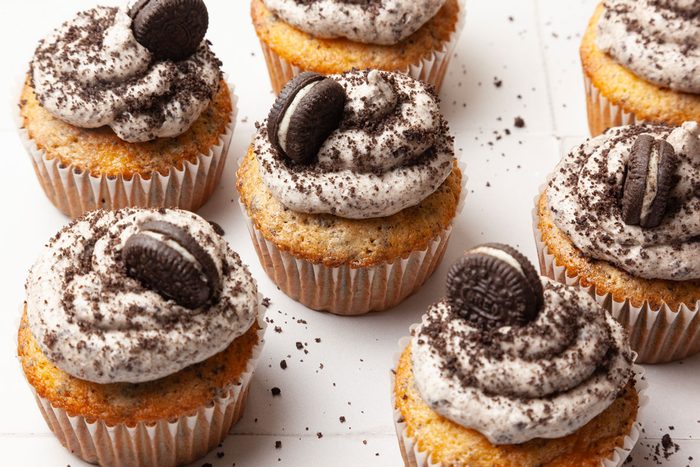 Taste of Home Oreo Cupcakes, on a white tile, oreo crumbs on surface