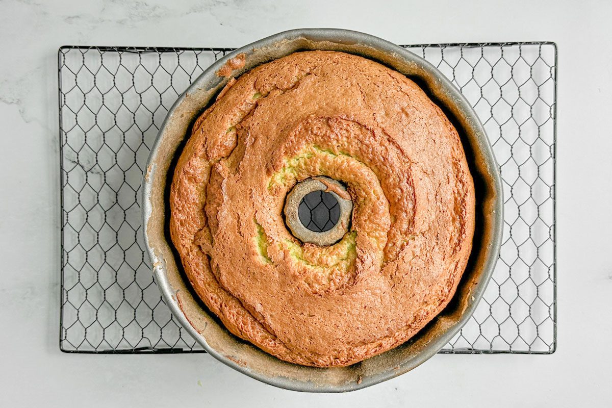 Taste of Home Pistachio Bundt Cake in a fluted bundt pan on a wire rack on a marble surface