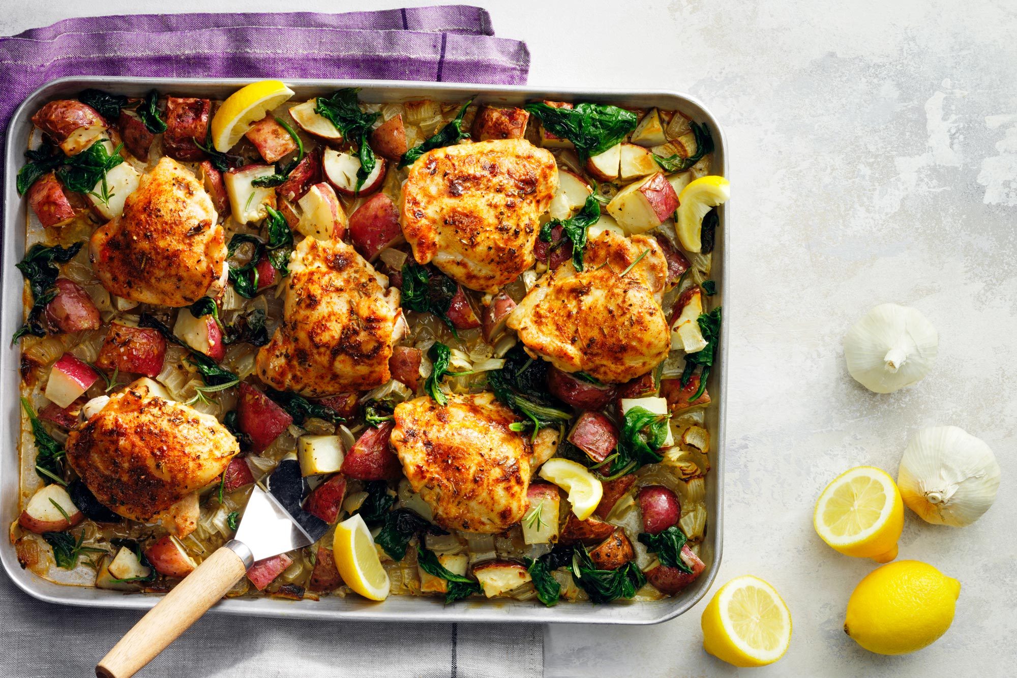 Sheet Pan Chicken And Veggies Served in a pan with lemon slices