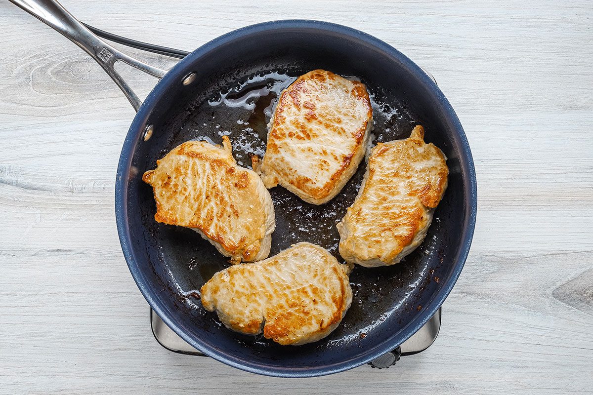 Browned pork chops in the skillet for a recipe from Taste of Home.