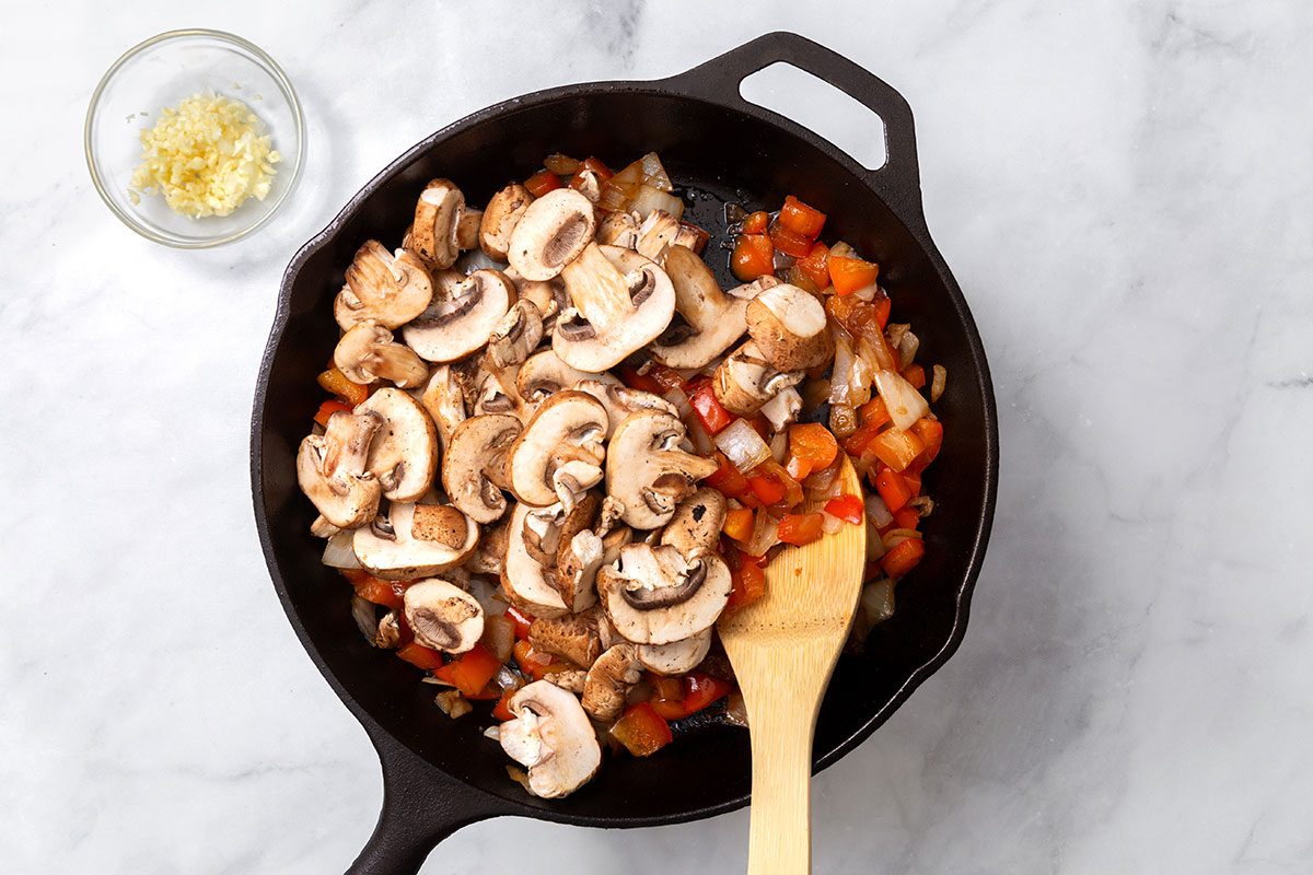 Onion, red pepper and sliced mushrooms being sauted in a large skillet for step three of Steak Pizzaiola recipe for Taste of Home