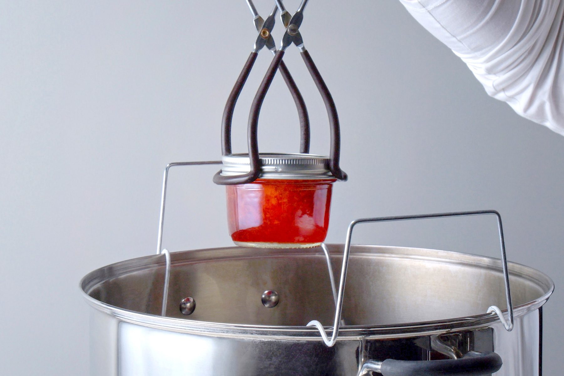 Eye angle shot of place jars into a canner with simmering water