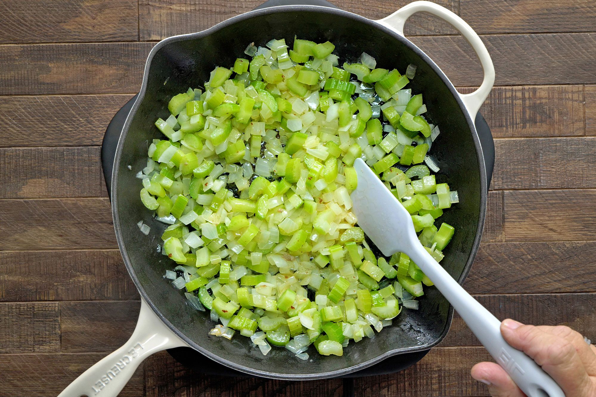 saute celery and onions in butter in a large skillet; Wooden Background;