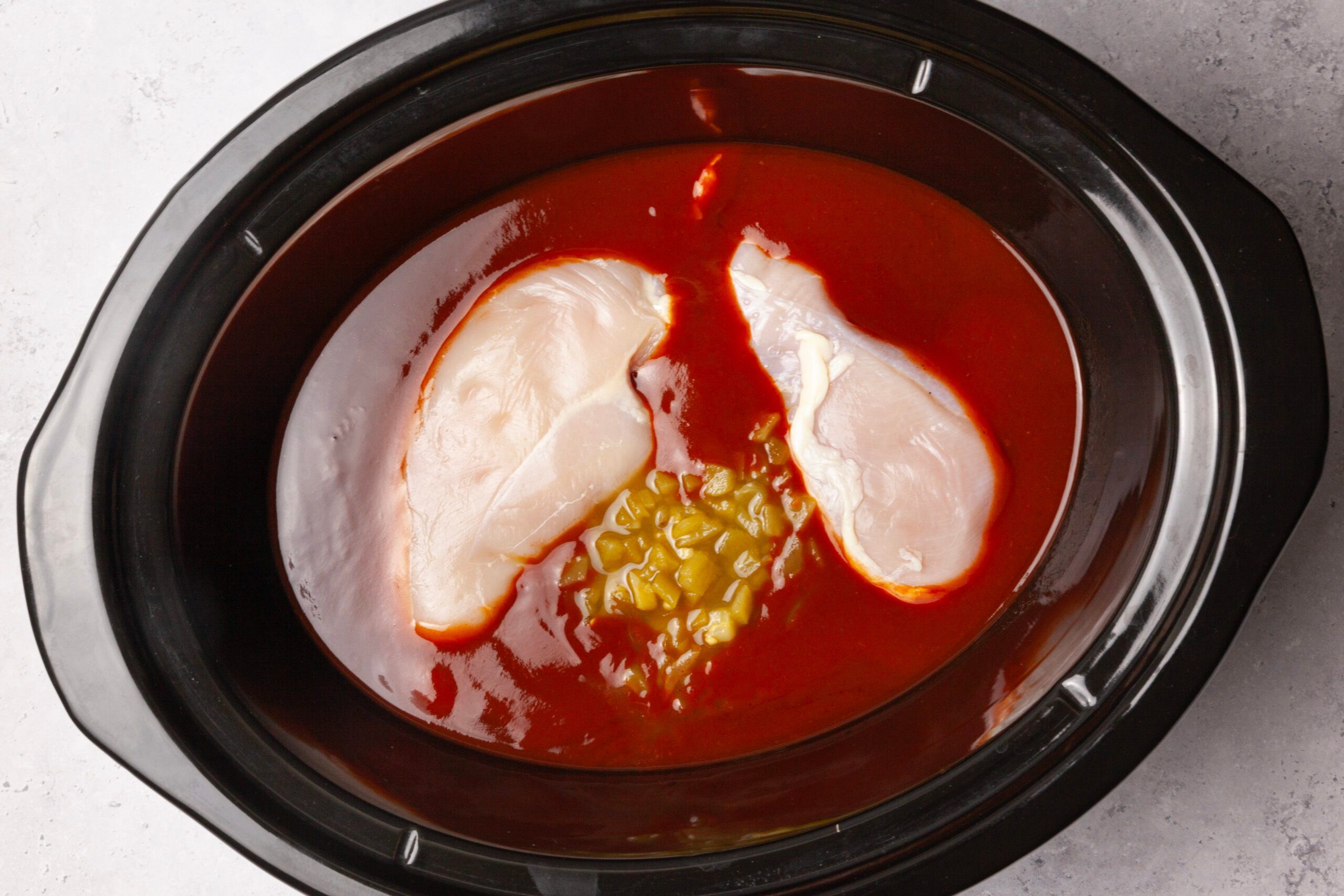 Step 1 of Taste of Home Crock-Pot Chicken Enchiladas is to combine the chicken, enchilada sauce and chiles. Cook, covered, on low for 6 to 8 hours or until the meat is tender.