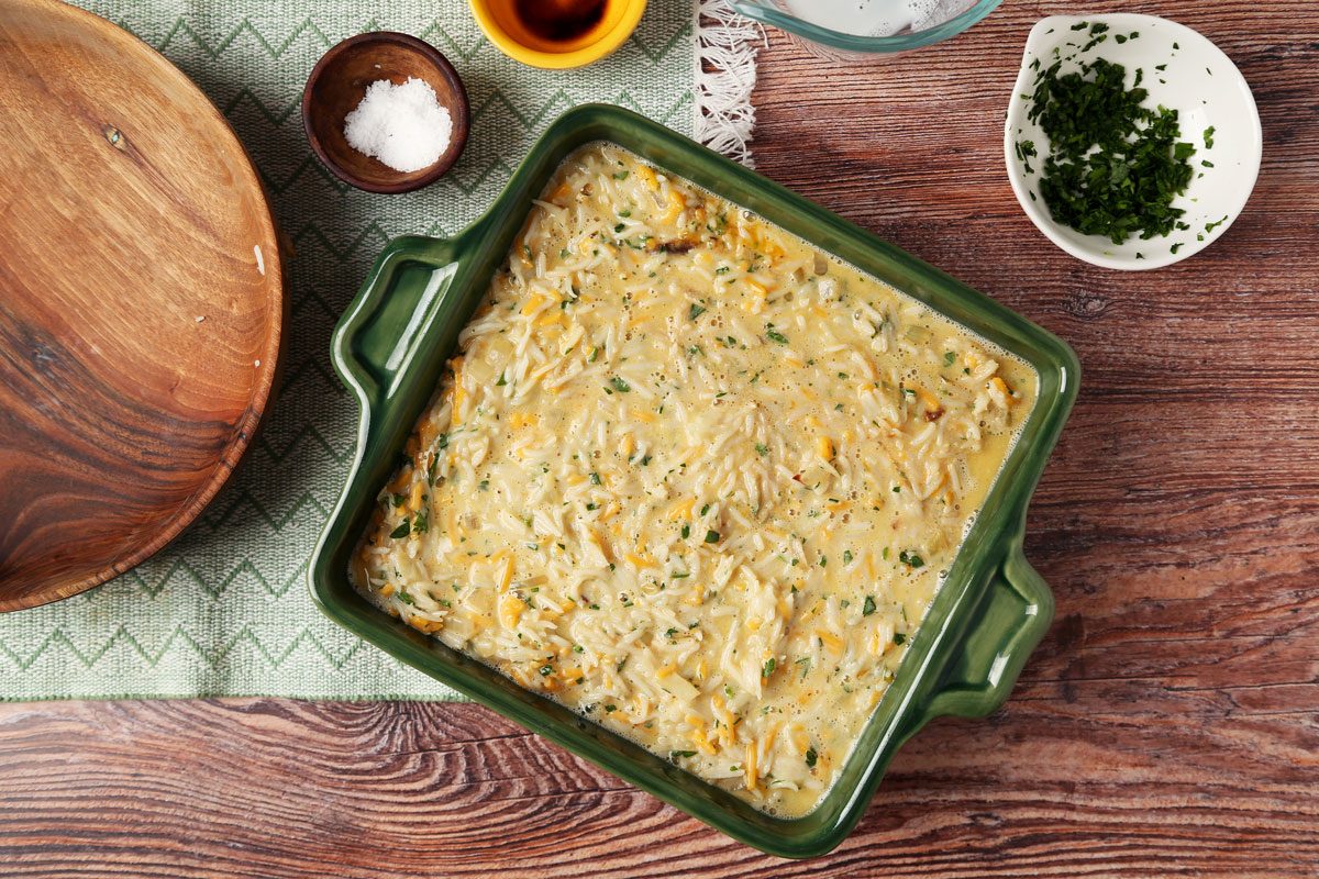 Process of making Taste of Home's Cheesy Rice Casserole in a green baking dish on a wooden surface.