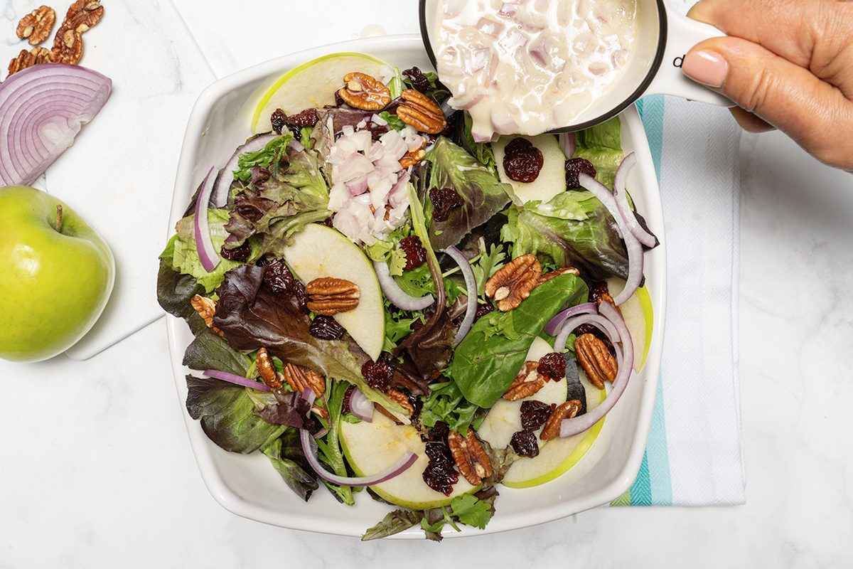 Pouring the dressing over the salad