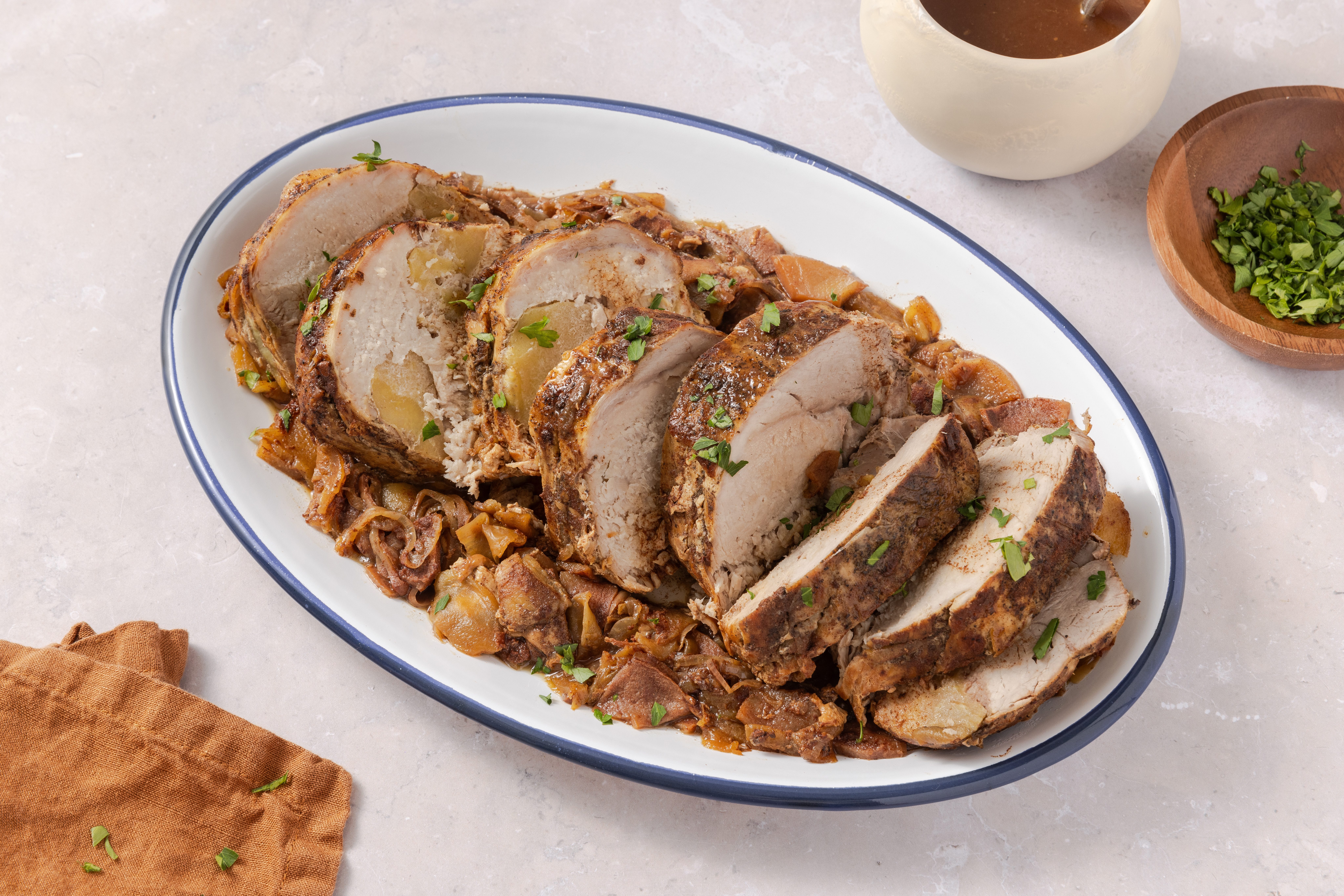 Apple pork loin ready and served with fresh parsley to garnish.