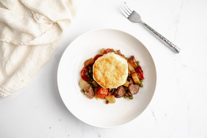 Overhead beauty shot for Taste of Home Beef Potpie with Biscuits being served on a plate.