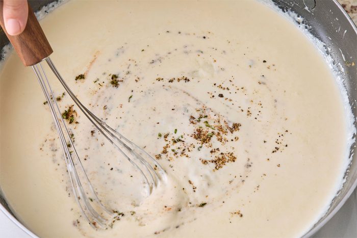 Close shot of stir in thyme; nutmeg; remaining 1/2 teaspoon salt and remaining 1/4 teaspoon pepper; remove from heat; whisk marble surface;