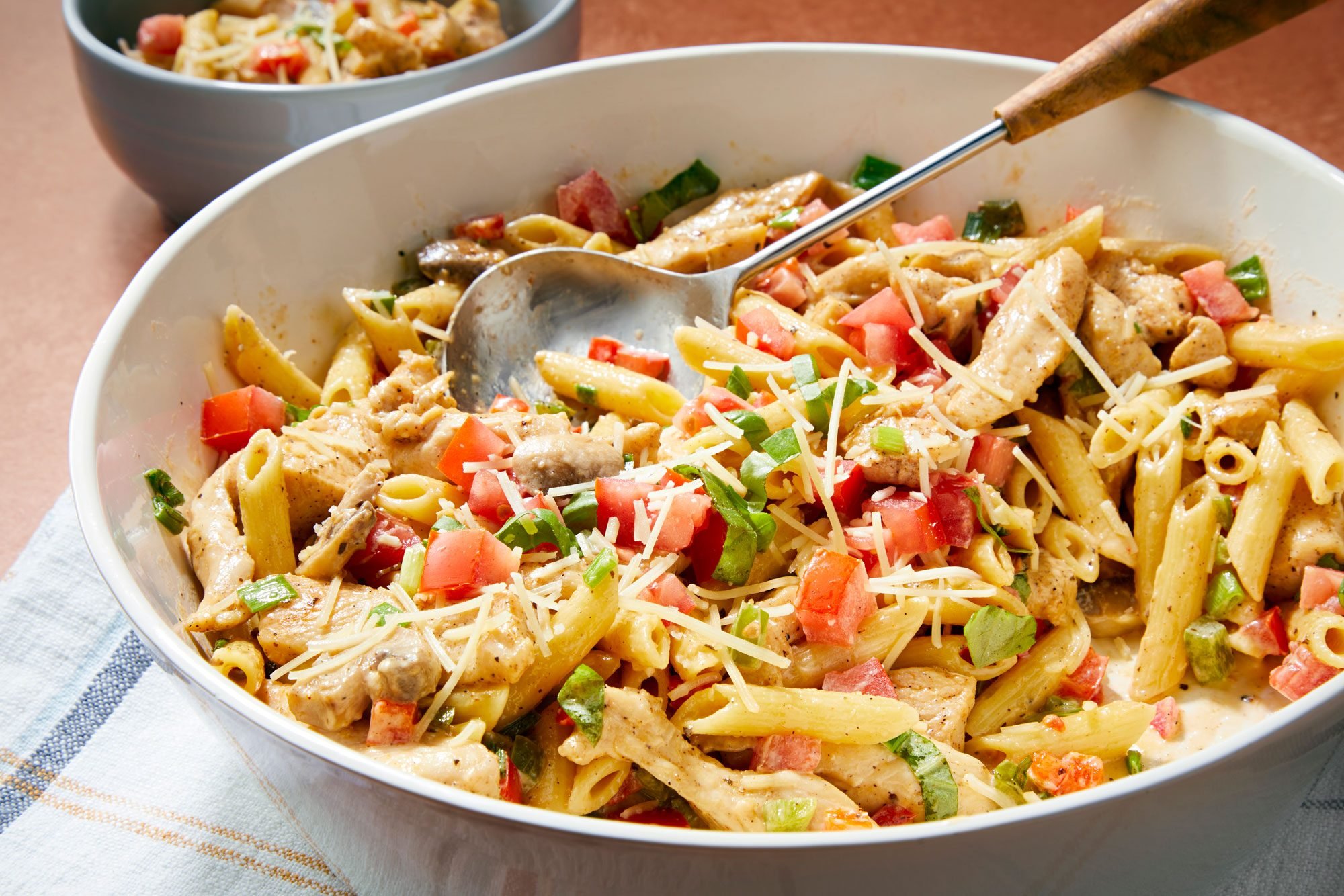 3/4th shot of Cajun Chicken Pasta served in a large bowl; kitchen napkin;