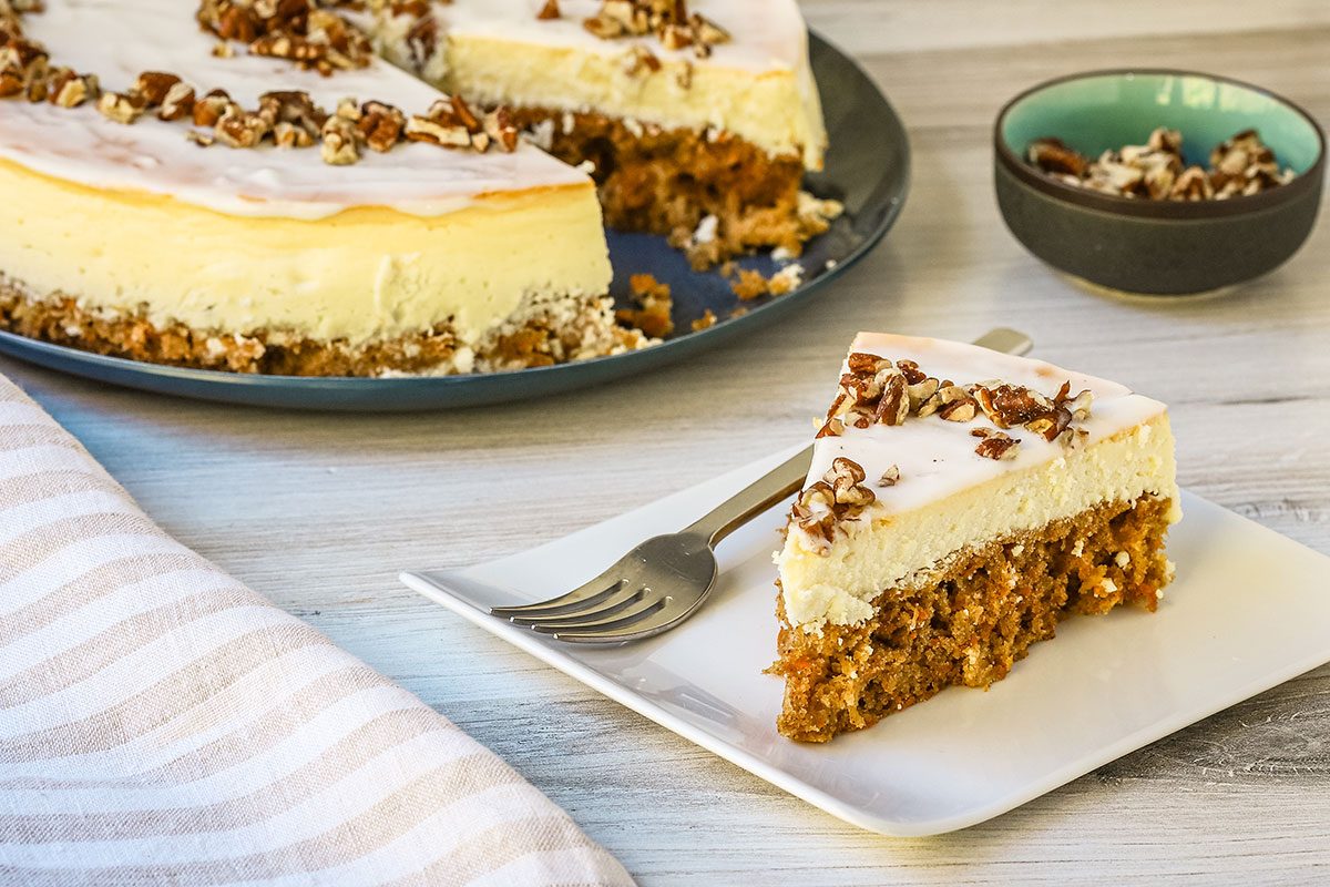 A carrot cake cheesecake, sliced and ready to serve.