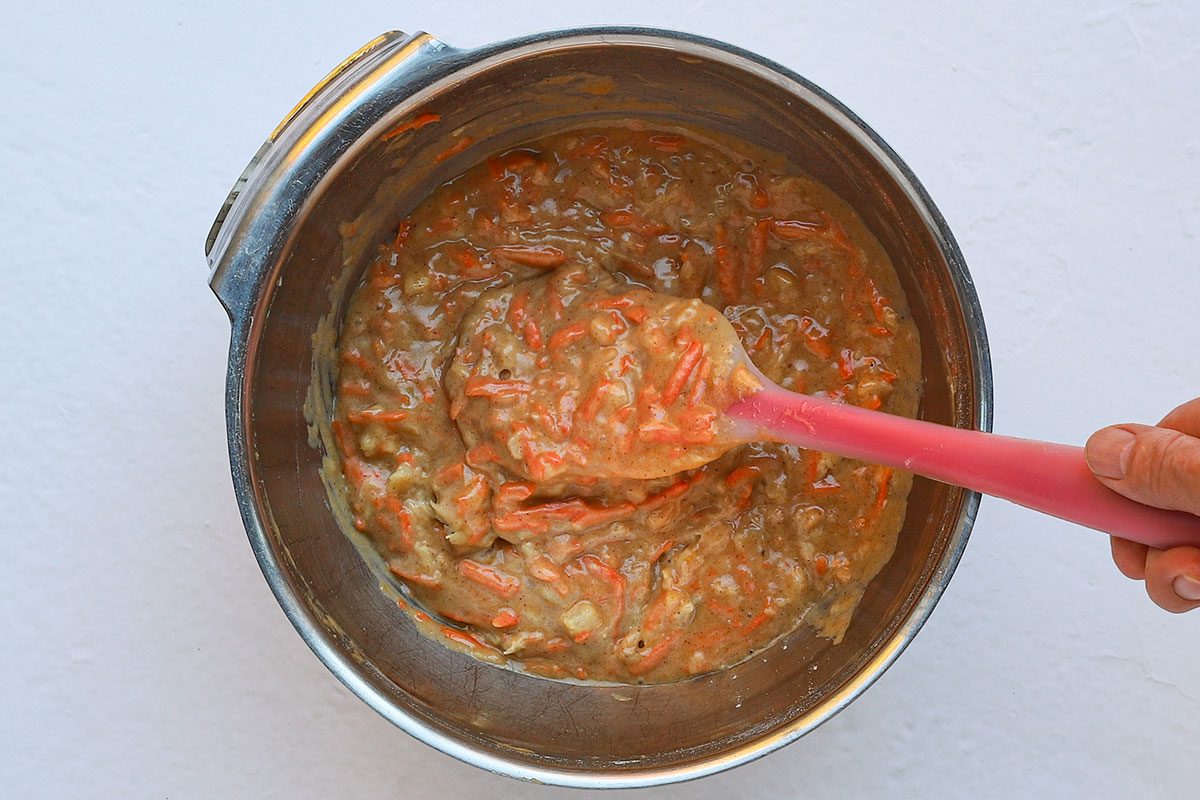 Folding carrots and pineapple into carrot cake batter.