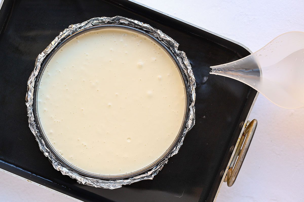 Carrot cake cheesecake in a roasting pan and ready to bake.