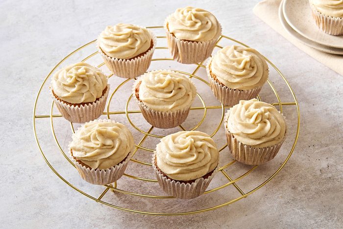 Frosted chai cupcakes on a circular wire rack
