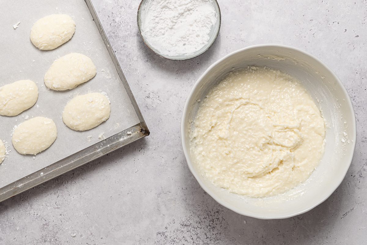 Bowls With Cream Cheese And Coconut Batter And Pan With Easter E