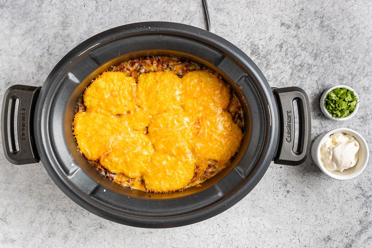 Taste of Home Crockpot Tamale Pie photo of topping the ingredients with cheese.