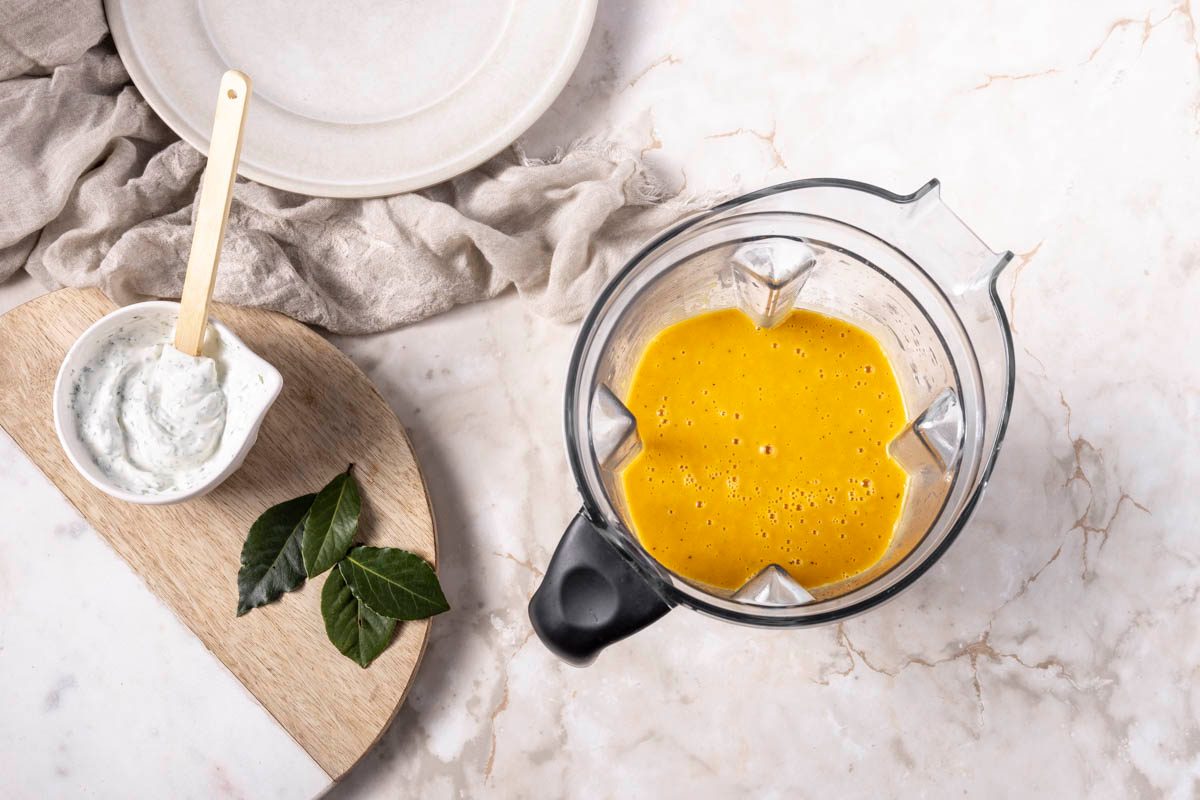 In a blender, add half the broth mixture and half the roasted butternut squash, and process until smooth for Curried Butternut Squash Soup