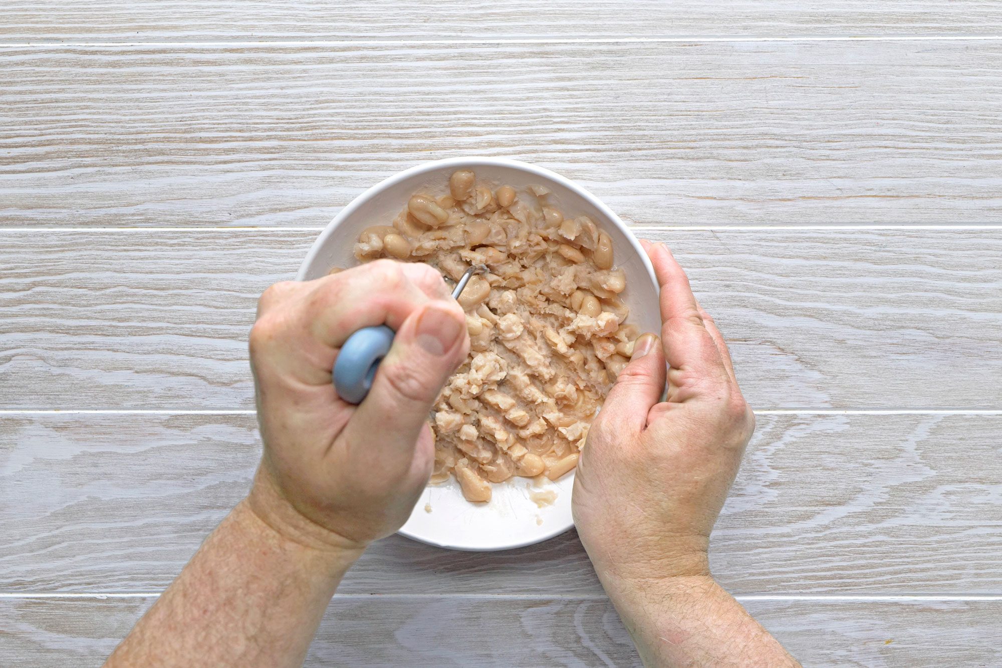 Pour 1 can of beans in a small bowl and mash slightly