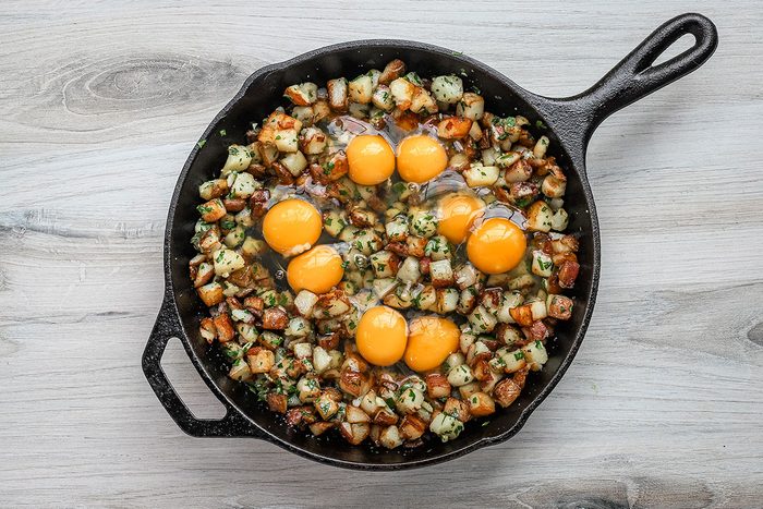 Eggs are added to the potatoes in the cast iron skillet and the dish is ready for the oven.