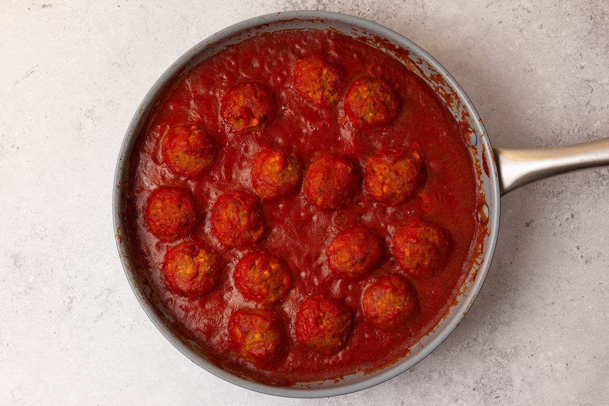 Step 6 of Taste of Home Lentil Meatballs is to add the cooked meatballs to a pan, pour in marinara sauce and bring to a simmer