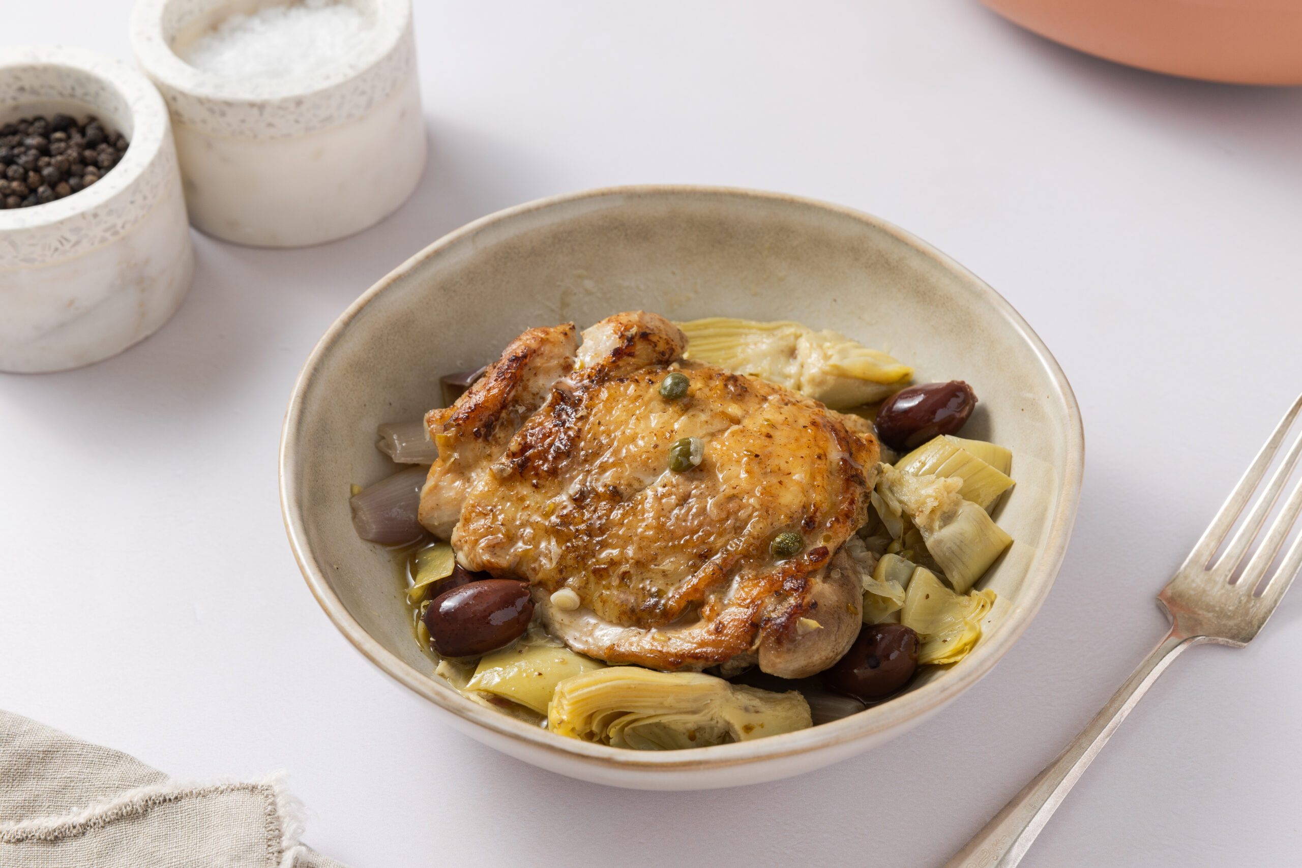 Mediterranean chicken thighs ready served in bowl.