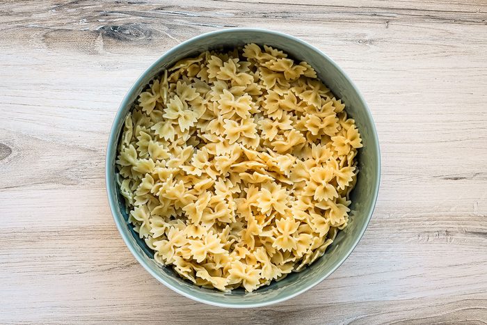 A large bowl with bow tie pasta for a Mexican street corn pasta salad.