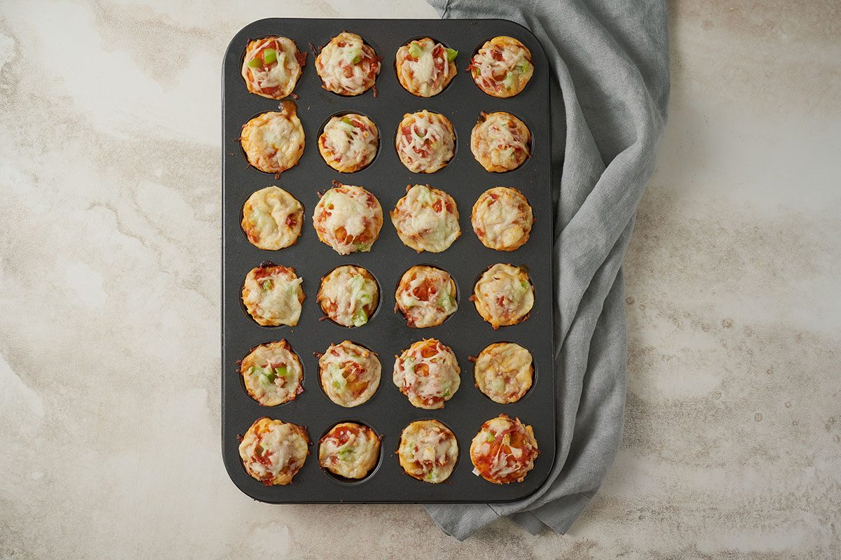Overhead view of the Pizza Bites after baking in the oven, with the crusts golden brown and the cheese melted and bubbly for the Taste of Home Pizza Bites recipe.