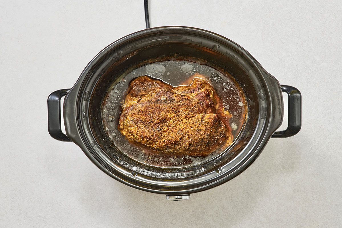 Cooked pork butt roast in a slow cooker