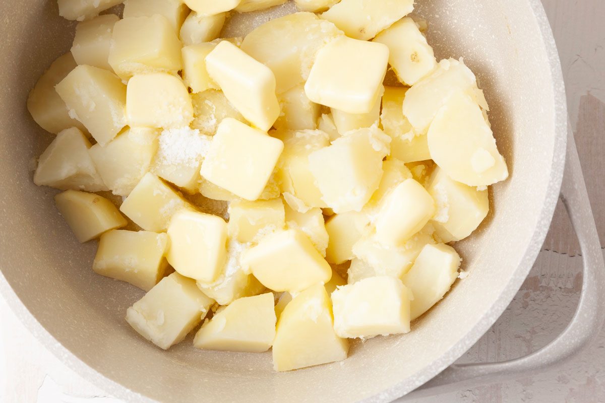 Step 2 of Taste of Home Potato Puree is to place the potatoes in a Dutch oven and add enough water to cover them. Season the water with 1/2 teaspoon of salt and bring to a boil. Next, reduce the heat and cook the potatoes, uncovered, until they are very tender, which will take 20 to 25 minutes. Then, drain the liquid and return the potatoes to the Dutch oven pan. Stir in the salt and 8 tablespoons of cubed butter and stir until the butter has melted.