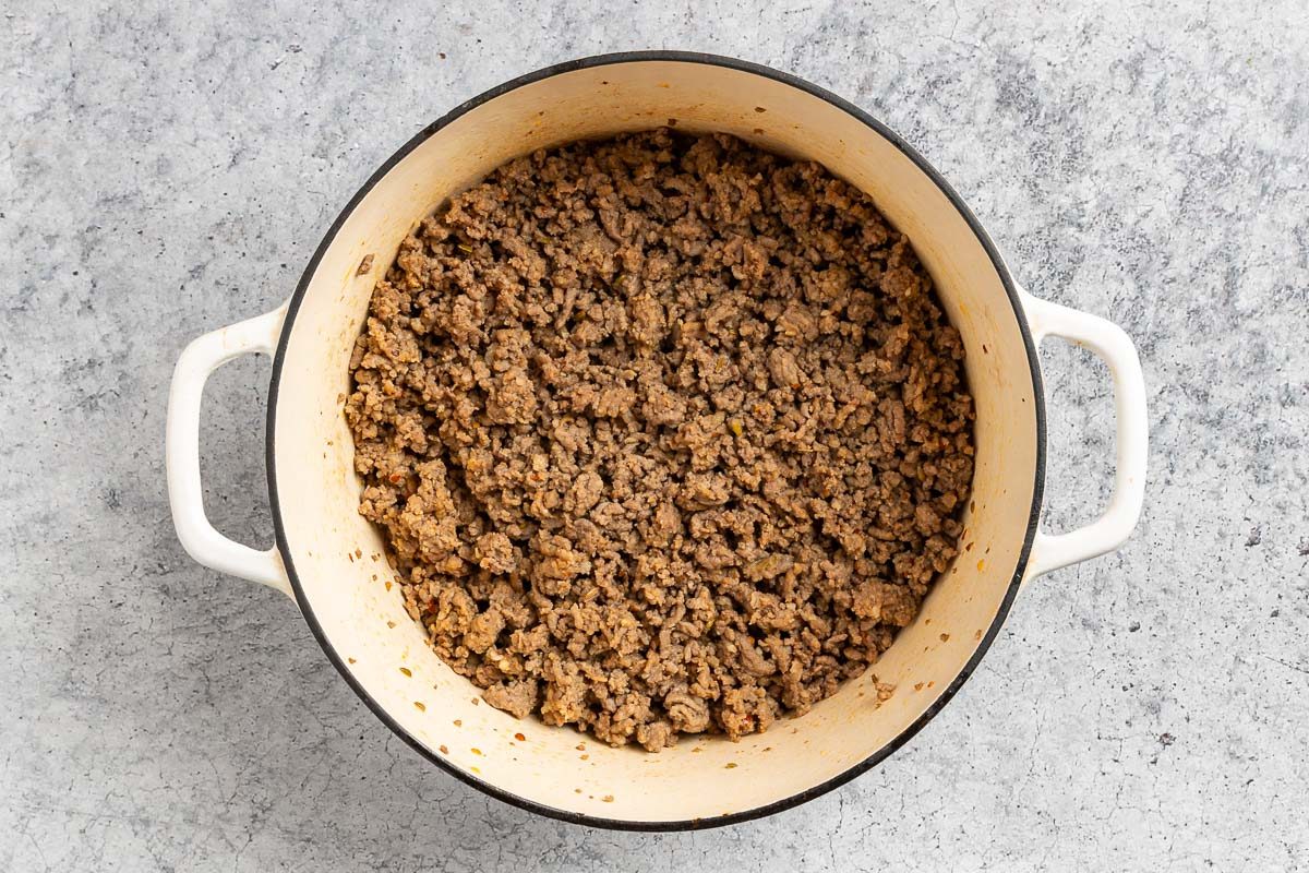 Taste of Home Spicy Chili Recipe photo of the cooked ground beef and Italian sausage in a Dutch oven.